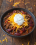 keto friendly chili in a bowl, topped with cheese and sour cream